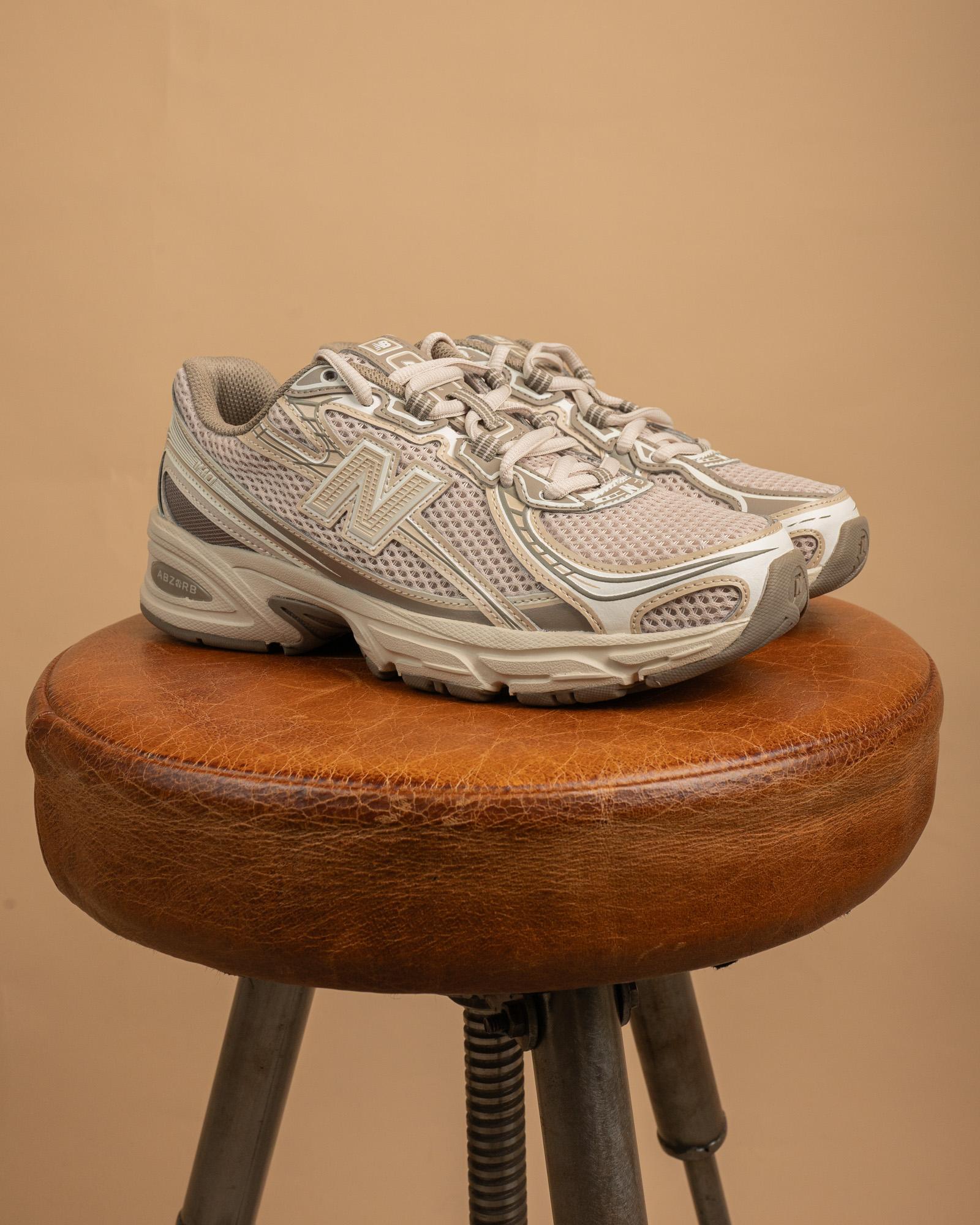 Suola in gomma nera e intersuola color panna delle sneakers New Balance 740, design retro-running tecnico anni 2000.