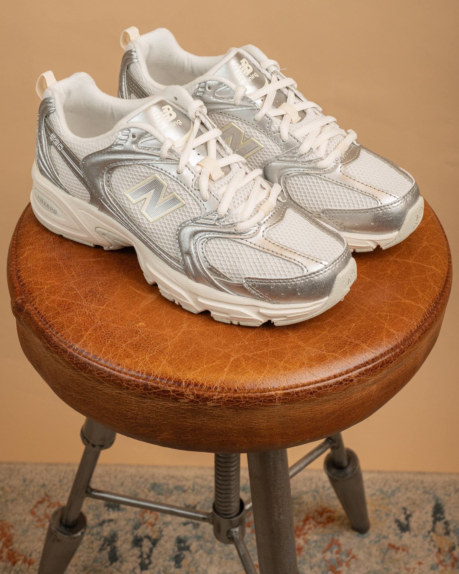 Sneakers New Balance 530 Silver Metallic in mesh bianco con sovrapposizioni in argento metallizzato e dettagli blu navy.