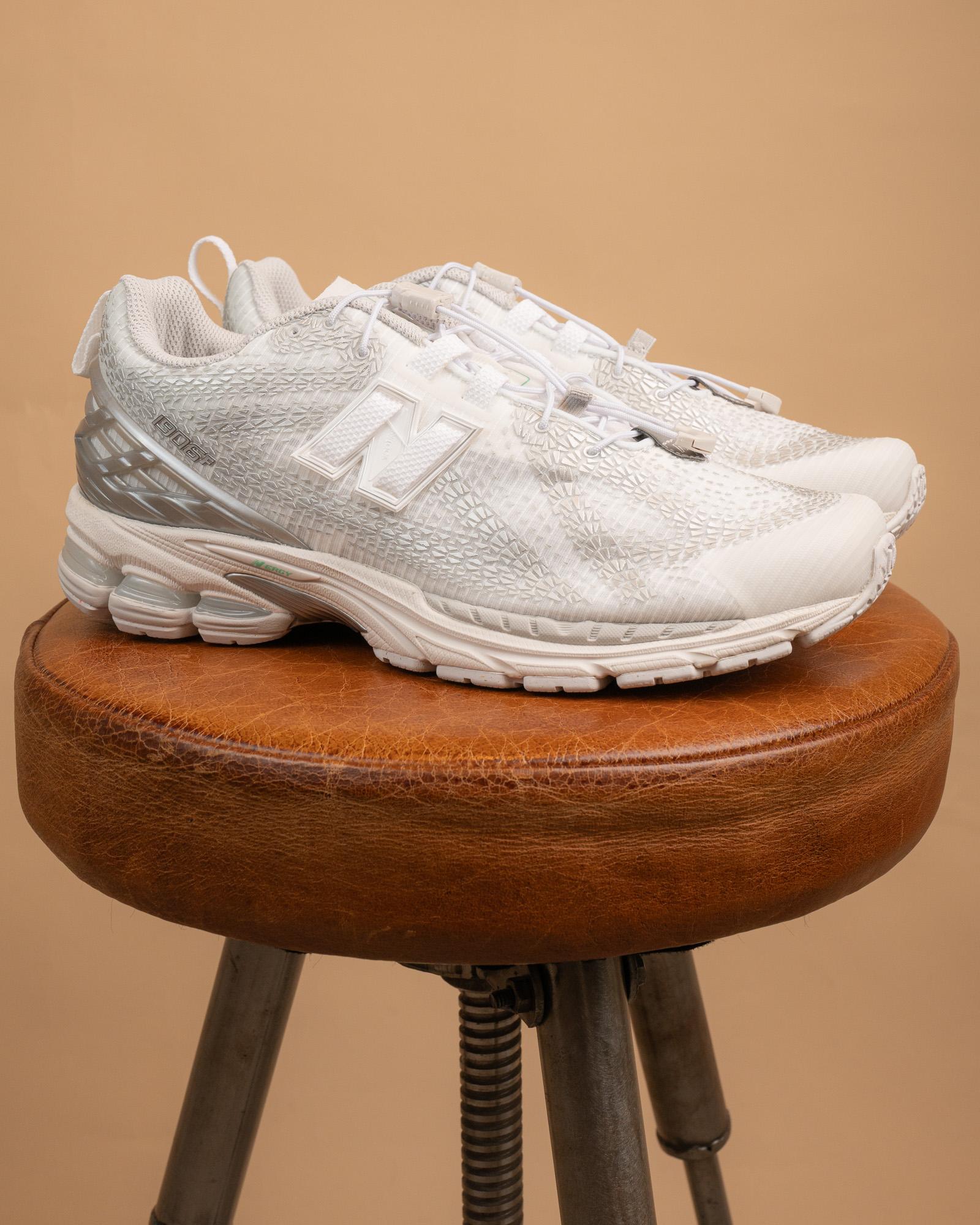 Dettaglio della gabbia del tallone in TPU e del sistema di allacciatura N-Lock delle sneakers New Balance 1906R argento e bianco.