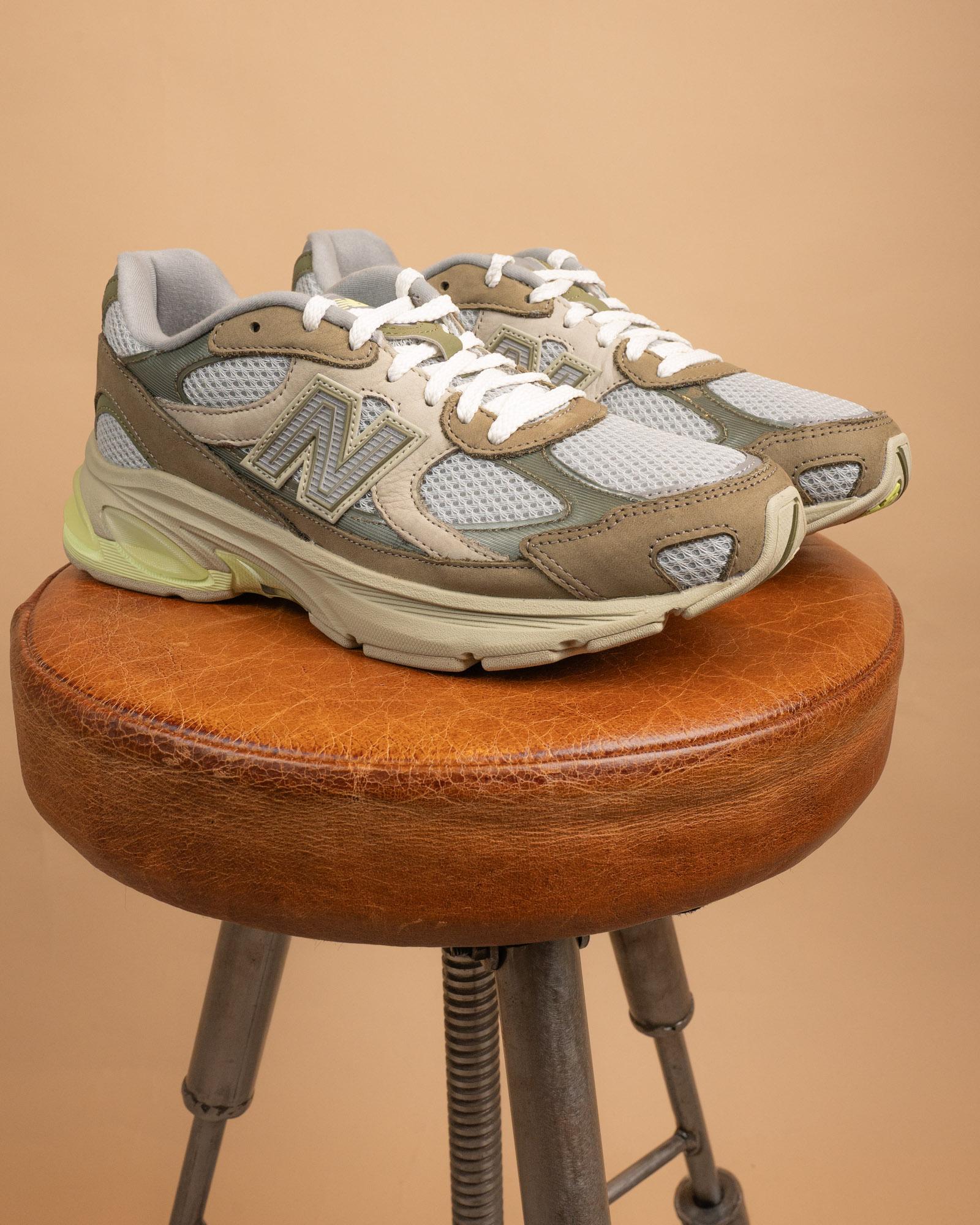 Primo piano dei dettagli riflettenti e della tomaia multistrato delle New Balance 2010 Covert Green/Dry Lime.