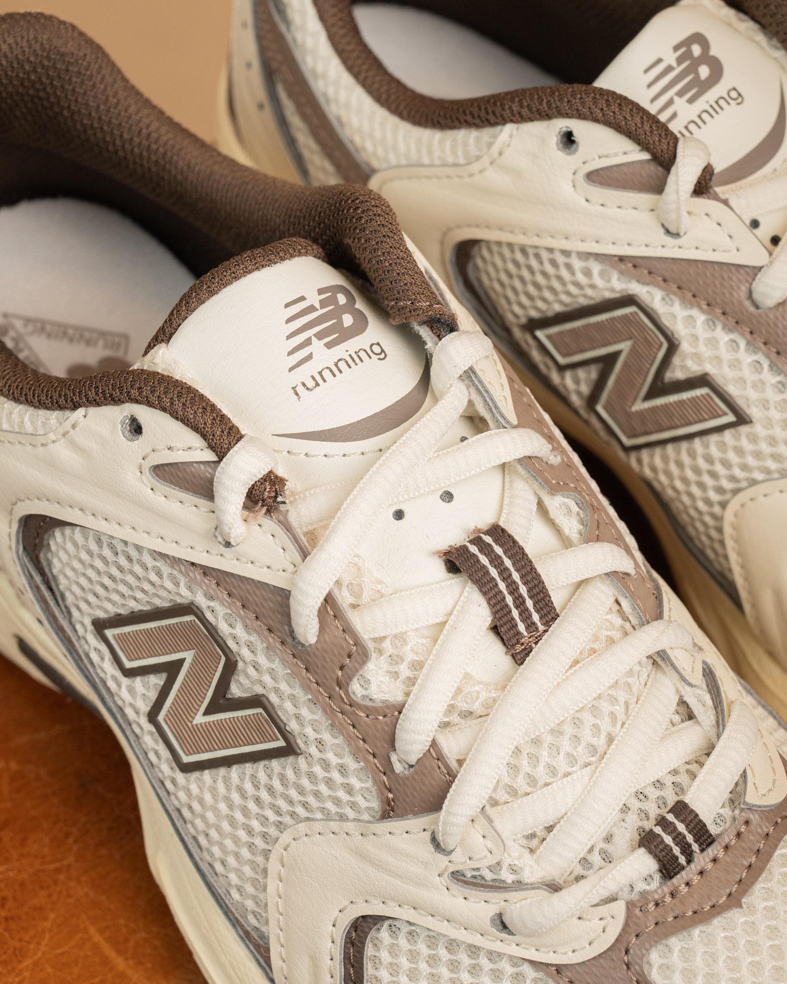 Dettaglio del logo New Balance "N" sulle 530 Brown, scarpe running vintage style con intersuola ABZORB color panna.